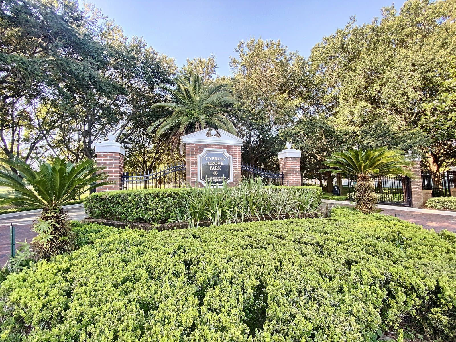 Cypress Grove Park entrance sign with tropical landscaping