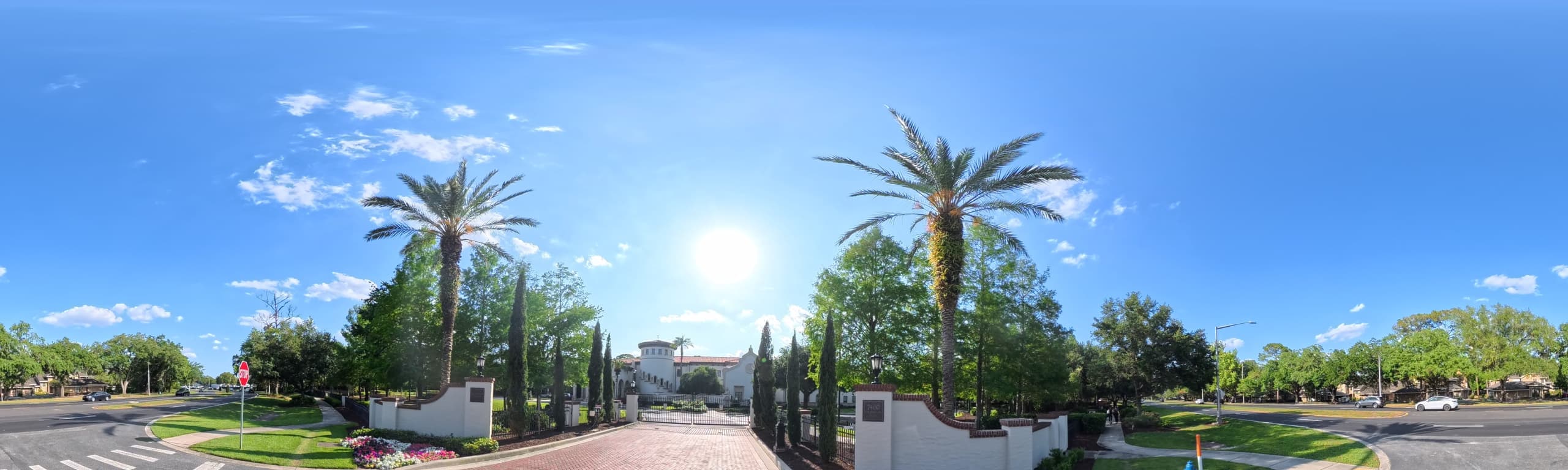 Gated entrance at Dr. Phillips Quarters with white walls and tall palms