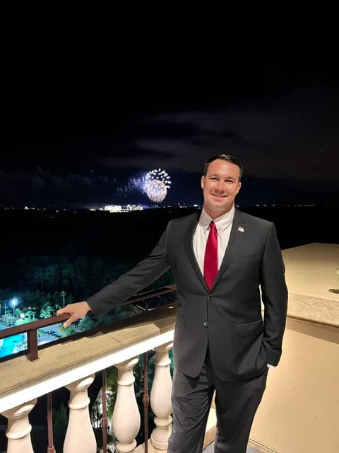 Ryan Solberg on a Four Seasons Resort Orlando balcony at Golden Oak with Walt Disney World fireworks behind him